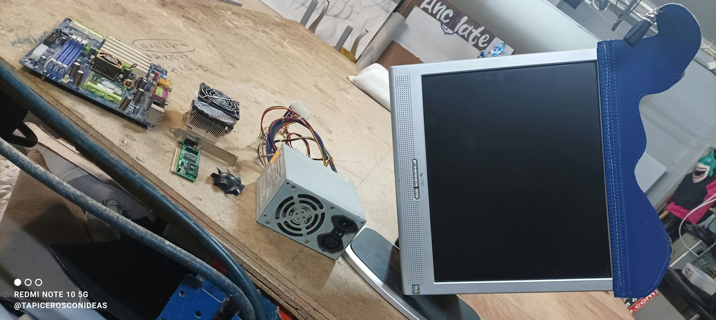 Parti di computer smontate disposte su un banco da lavoro in legno.